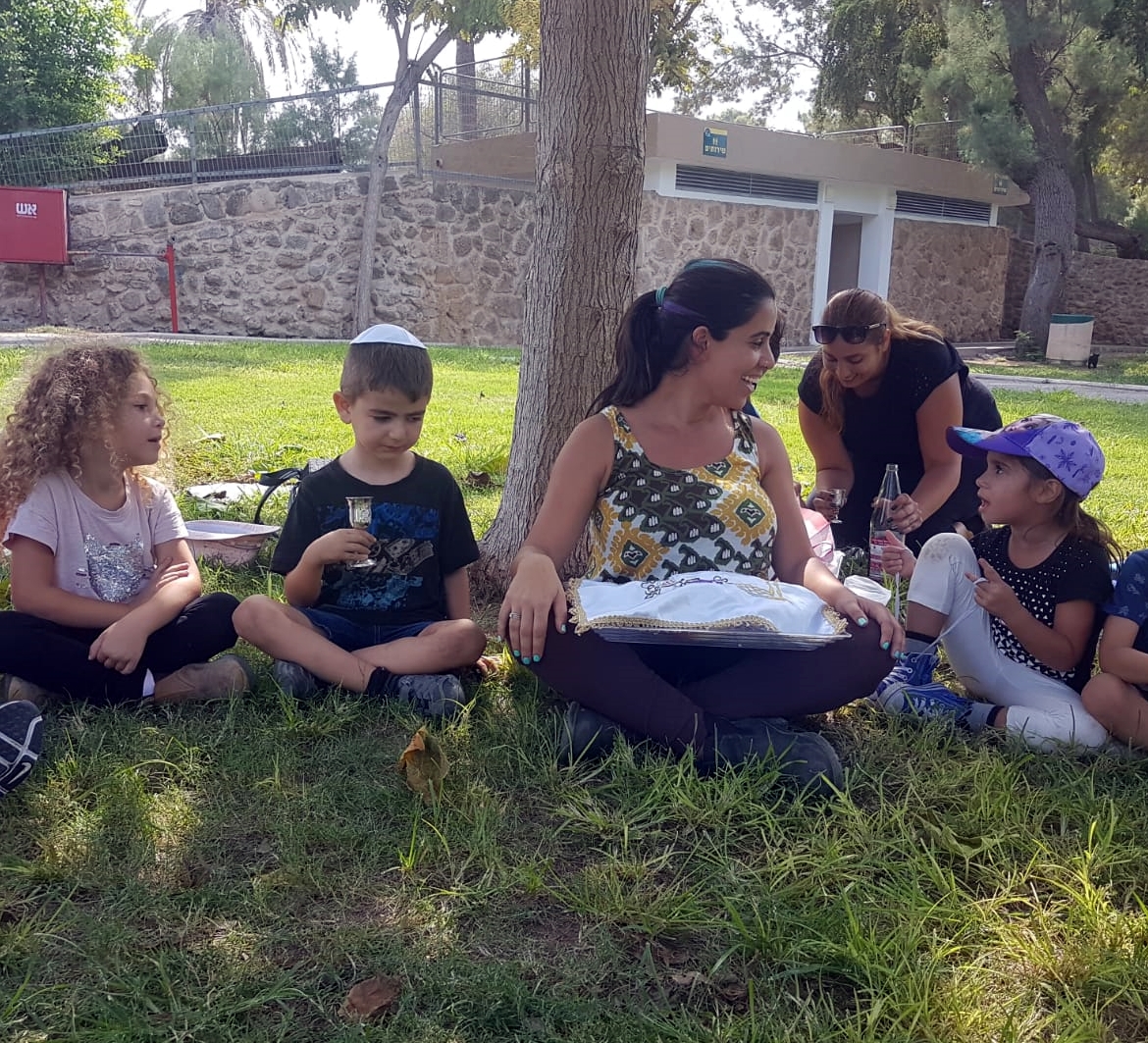 גננת וילדים על הדשא