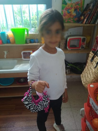 ילדה מחזיקה תיק שארגה בעצמה